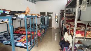 迈索尔Mysuru dorm-sgh的房间里有一组双层床，上面有人