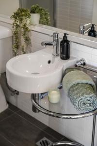 a bathroom with a white sink and a mirror at Stylish Apartment in Melbourne in Melbourne