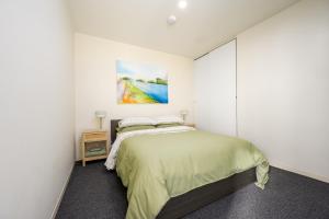 a bedroom with a bed and a painting on the wall at Stylish Apartment in Melbourne in Melbourne