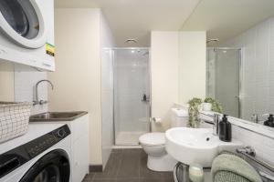 a white bathroom with a toilet and a sink at Stylish Apartment in Melbourne in Melbourne +12 photos