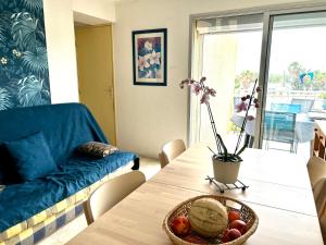 un salon avec une table avec un bol de fruits dessus dans l'établissement Au balcon de la mer, appartement à Marseillan plage, à Marseillan 17 autres photos