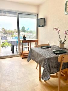 une salle à manger avec une table et un balcon dans l'établissement Au balcon de la mer, appartement à Marseillan plage, à Marseillan