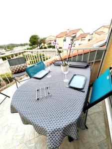 une table avec deux ordinateurs portables posée sur un balcon dans l'établissement Au balcon de la mer, appartement à Marseillan plage, à Marseillan