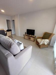 a living room with a couch and a tv at Zona Güemes 2 ambiente N 503 in Mar del Plata