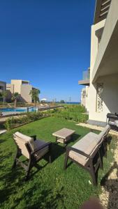 two benches and a picnic table next to a building at boho elsokhna in Ain Sokhna