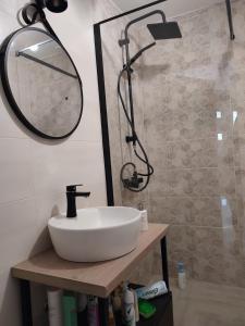 a bathroom with a white sink and a mirror at Sea & Silence Holiday House in Merdari