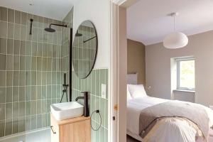 ein Badezimmer mit einem Bett, einem Waschbecken und einem Spiegel in der Unterkunft A Beautiful 3 Bedroom 17th Century Stone cottage in Llanddyfnan + 34 Fotos