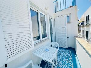 a white table and a chair on a balcony at Acquario - Immobilevante in Ponza