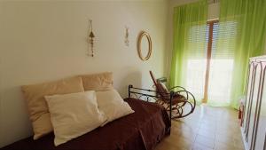 a bedroom with a couch and a window with green curtains at Casa di Silla in Torre del Lago Puccini +2 photos