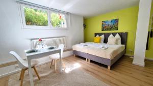 une chambre avec un lit, un bureau et une table dans l'établissement Nova Freiburg Dunantstraße, à Fribourg-en-Brisgau