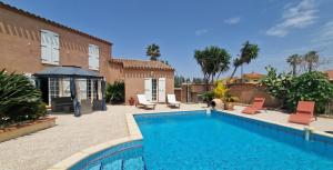 a swimming pool in front of a house at La Villa Catalane in Bompas