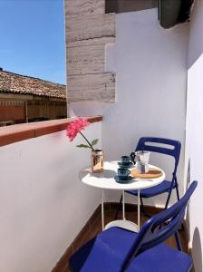 een klein tafeltje en stoelen op een balkon met een bloem bij Mansarda la Graziosa in Rimini