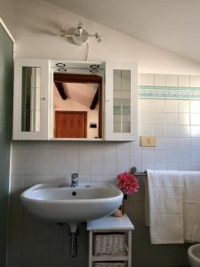 een badkamer met een wastafel en een spiegel bij Mansarda la Graziosa in Rimini