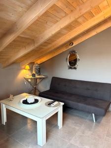 ein Wohnzimmer mit Sofa und Tisch in der Unterkunft Aneli-Attic Stay in Nafplio in Nafplio