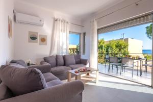a living room with a couch and a table at Era Suites Lagonisi in Kalívia Thorikoú