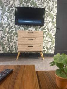 a television on top of a dresser with a desk at Chambre Studio B&B in Mazamet
