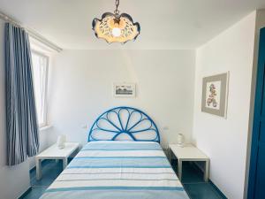 a bedroom with a blue bed and two tables at Acquario - Immobilevante in Ponza
