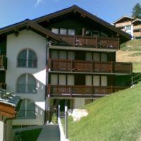 ein großes Gebäude auf einem Hügel in der Unterkunft Studio Collinetta in Zermatt