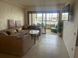 a living room with a couch and a table at Sunny modern Apartment- Ocean & Pool view in Al Mansouria in Mansouria