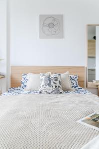 een slaapkamer met een groot bed met blauwe en witte kussens bij Nemunas A respite Studio 8 in Druskininkai