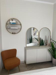 - un miroir sur une commode dans une pièce avec une chaise dans l'établissement Apartament Sikorki, à Sianożęty