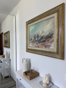 a painting on a wall above a white table at Villa Casavecchia Caselli in Dicomano