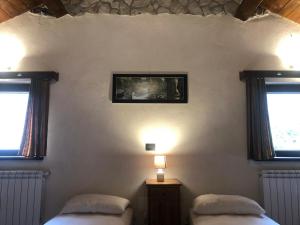 een slaapkamer met twee bedden en twee ramen bij Aia dell'Orso in Campoli Appennino