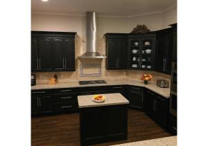 a kitchen with black cabinets and a bowl of fruit on the counter at A Luxury Mediterranean Retreat in Spring