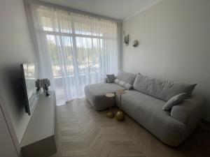 un salon avec un canapé et une grande fenêtre dans l'établissement Apartament Sikorki, à Sianożęty