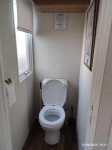 un piccolo bagno con servizi igienici e finestra di CHEZ ISA - Mobil home 2 ch - vue direct sur mer a Le Portel