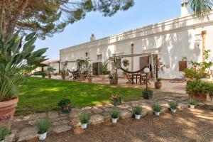 a garden with potted plants in front of a building at Agriturismo La Stornara, Petfriendly & EV Friendly in Ginosa Marina