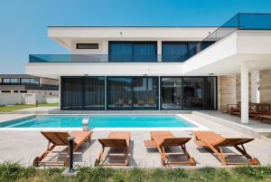 DračanにあるVilla Noaのスイミングプールと椅子が備わる家