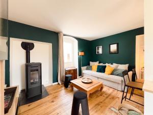 a living room with a couch and a wood stove at Gîte de Charme "Le Cocon du Diois" - Calme Absolu in Laval-dʼAix