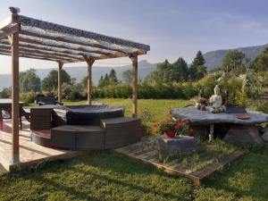 a pergola with a couch and a table in a yard at Maison Cinona in Le Mont-Dore