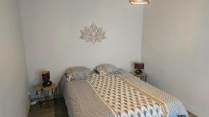 a bedroom with a bed and two side tables at Le Gîte Le Ladignacois - Cosy, calme & indépendant - 2 à 4 pers in Ladignac-le-Long