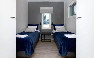 ein Zimmer mit zwei Betten und einem Fenster in der Unterkunft Luhtitalon alakerran huoneisto superior apartments vuokralle viikoksi 29 in Vierumäki