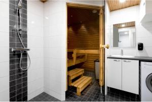 ein Badezimmer mit einer Sauna, einem Waschbecken und einem WC in der Unterkunft Luhtitalon alakerran huoneisto superior apartments vuokralle viikoksi 29 in Vierumäki + 8 Fotos