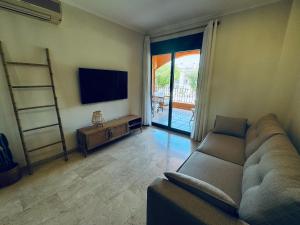 a living room with a couch and a flat screen tv at La Gavina Loft Xàbia & ARCADE in Jávea