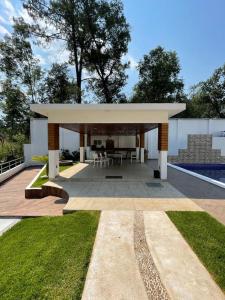 a pavilion with a table and chairs in a yard at Casa del bosque in Cerro Gordo +11 photos