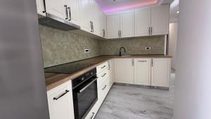 eine Küche mit weißen Schränken und einer Spüle in der Unterkunft Mara Stefania Apart Hotel Deluxe in Oradea