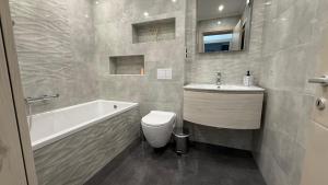 ein Badezimmer mit Waschbecken, Badewanne und Toilette in der Unterkunft Mara Stefania Apart Hotel Deluxe in Oradea + 14 Fotos