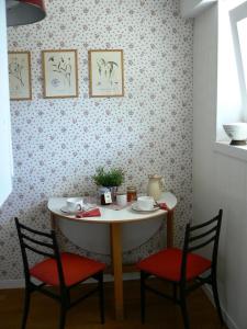 a table with two chairs and a table with cups and plates on it at Maison Bibian in Aosta