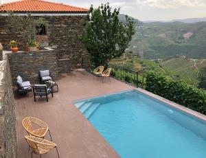 a swimming pool with chairs and a patio with a view at Quinta do Barrocal - Casa de Campo in Peso da Régua