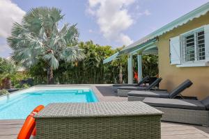 Una piscina con sillas al lado de una casa. en Villa Trezel - Saint-François, en Saint-François