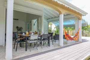 Un patio con una mesa y sillas en una terraza. en Villa Trezel - Saint-François, en Saint-François