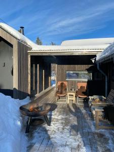 an outdoor patio with a fire pit and snow at Mountain Cabin With Sauna At Blefjell in Lampeland