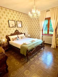 ein Schlafzimmer mit einem Bett und einem Kronleuchter in der Unterkunft Villa Margherite in Merizzo
