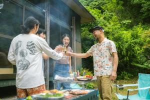 柏崎市ゲスト専用プライベートサウナ付き一棟貸し宿 In Utero的一群人站在桌子旁喝着饮料