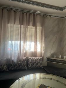 a room with a window and a glass table at Appartement Belyouneche in Belyounech 
