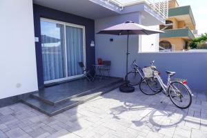 two bikes parked next to a house with an umbrella at L'Angolo di Mimma in Porto Cesareo